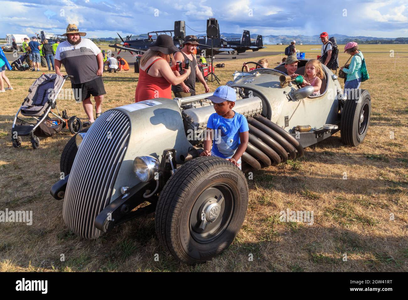 Enfants jouant sur une voiture personnalisée « Merlin Meteor », propulsée par un moteur de char Rolls-Royce Meteor, lors d'un spectacle aérien à Mount Maunganui, en Nouvelle-Zélande Banque D'Images
