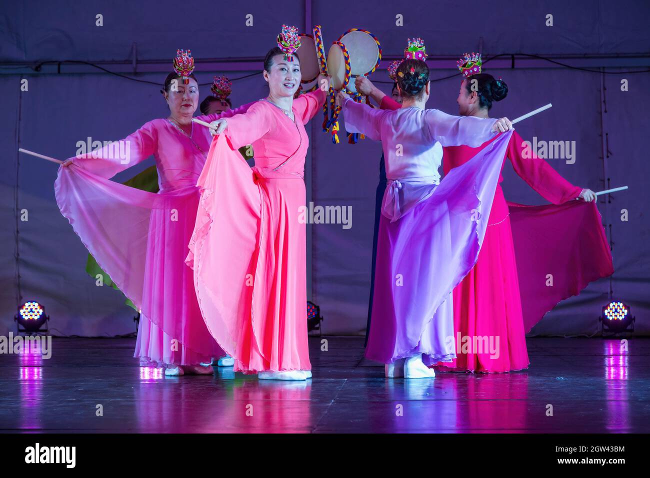 Un groupe de femmes coréennes dans des robes hanbok traditionnelles, dansant sur scène avec sogo (tambours à main) Banque D'Images