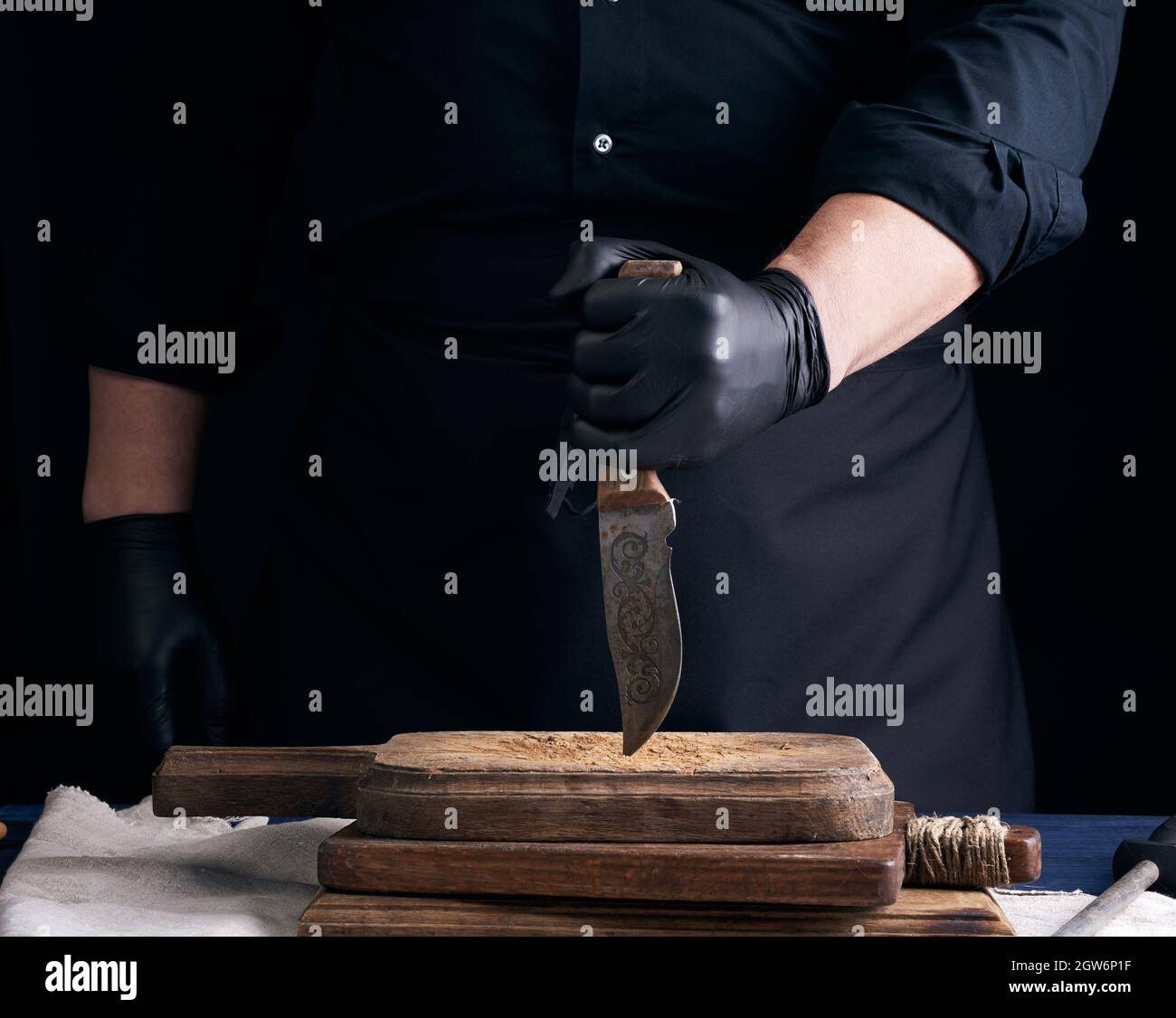 Le chef dans Une chemise noire et des gants en latex noir tient Un couteau  de cuisine Vintage pour couper la viande, la clé basse Photo Stock - Alamy