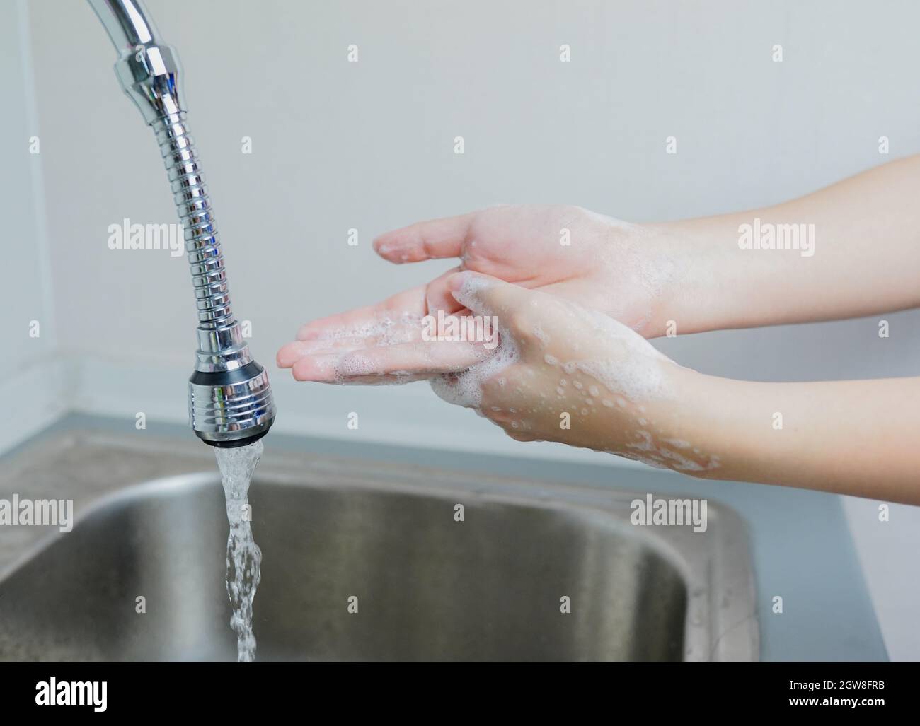 Femme se lavant les mains avec du savon à l'évier.Dans la situation Covid-19 coronavirus. Banque D'Images