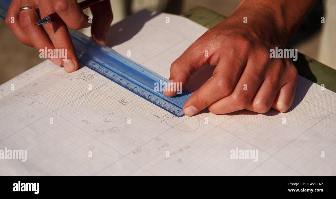 Archéologues desseins, dessine avec un crayon sur papier un dessin d'anciens objets archéologiques trouvés à l'excavation Banque D'Images