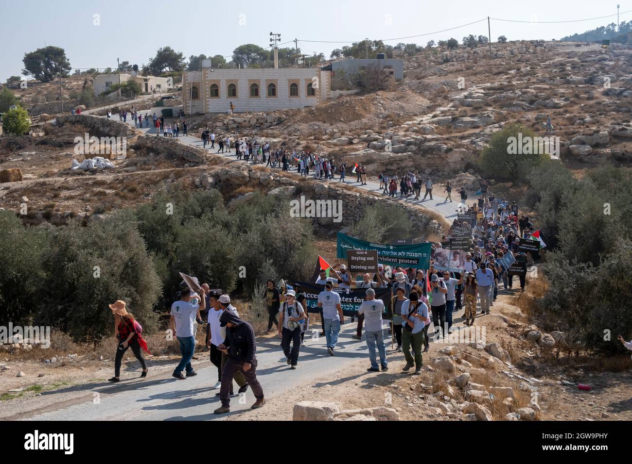 Des manifestants palestiniens et des militants israéliens pour la paix défilent ensemble dans le village palestinien d'al-Tiwani lors d'une manifestation contre la coupure de l'approvisionnement en eau des villages palestiniens, Et la solidarité avec le camp de bergers palestiniens Khirbat al-Mufaqara qui a été attaqué plus tôt cette semaine par des colons juifs dans les collines de South Hebron le 02 octobre 2021 en Cisjordanie, Israël. Au cours des deux dernières décennies, les autorités israéliennes ont tenté d'expulser les Palestiniens vivant dans la région des collines de South Hebron, sur le terrain de vivre illégalement dans les zones de feu militaires israéliennes. Banque D'Images