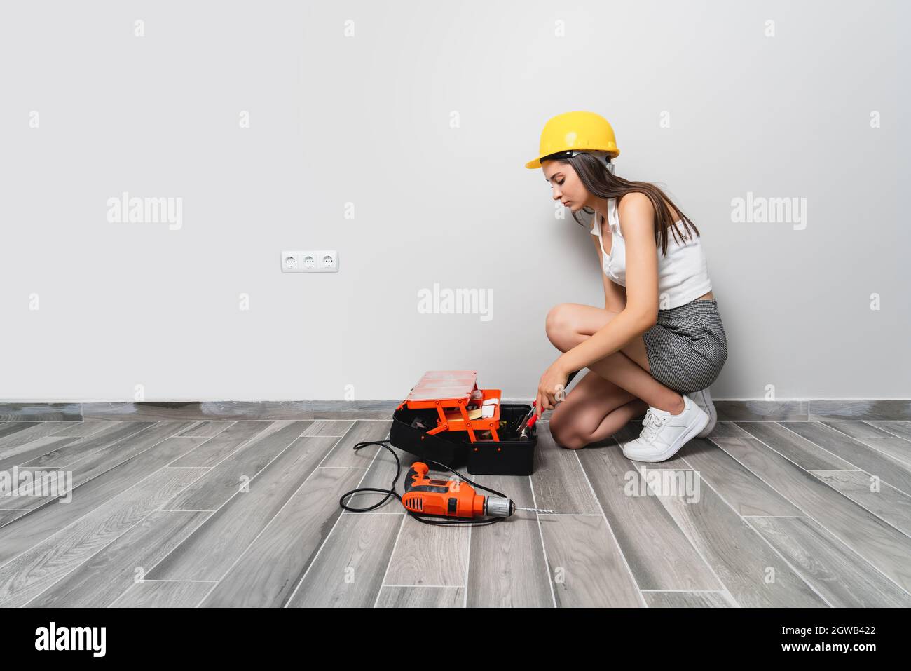 La jeune femme avec sac à outils prend quelques outils pour réparer l'entretien à la maison. Photo de haute qualité Banque D'Images