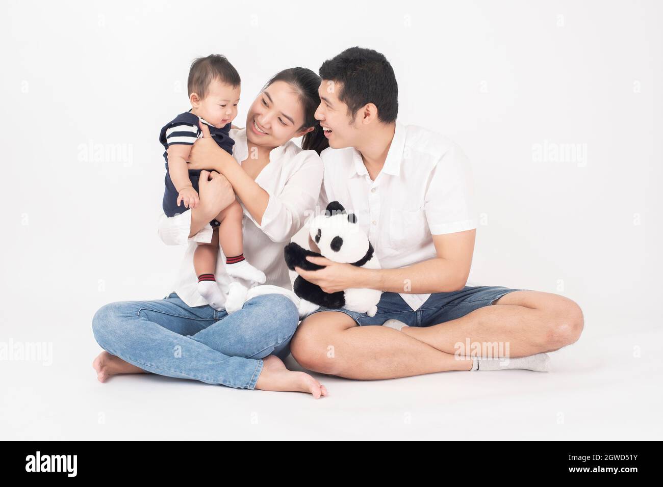 Parents assis avec bébé garçon sur fond blanc Banque D'Images