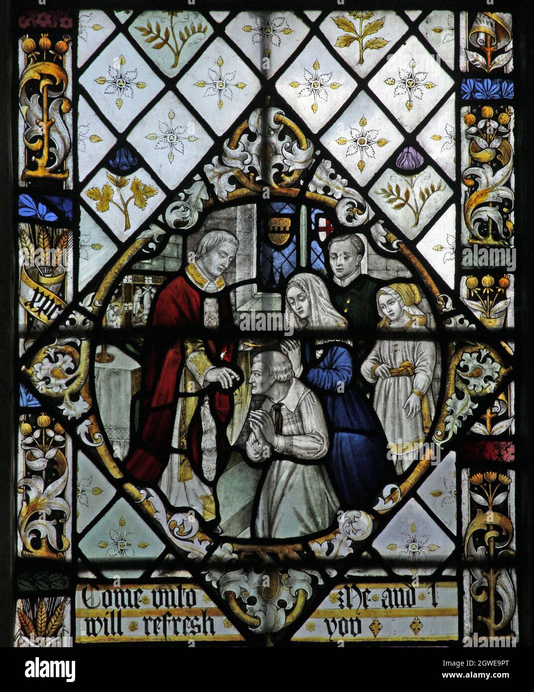 Détail d'un vitrail par Frederick Charles Eden (1864-1944); un prêtre donne la communion à une famille, l'église Steeple Aston Oxfordshire Banque D'Images