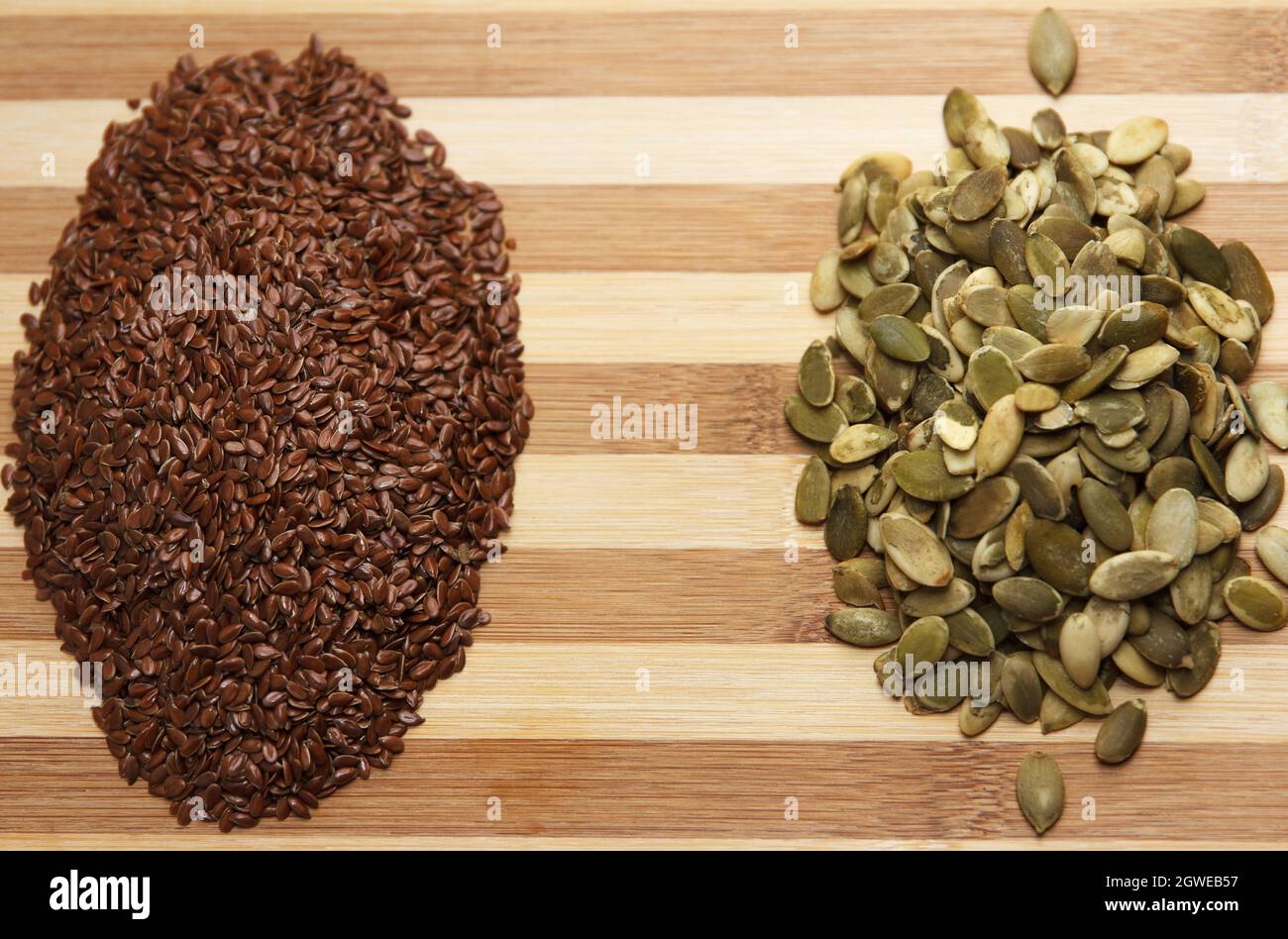 Deux diapositives de graines de citrouille crues sèches et de lin, reposent une diapositive sur une table, en gros plan Banque D'Images