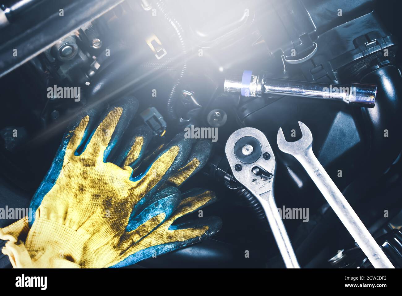 Les outils mécaniques se placent sur le véhicule moteur, tels que des gants, une clé à douille, une clé mixte, un concept d'entretien de voiture. Banque D'Images