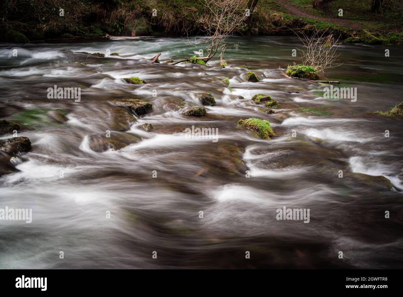 Longue exposition d'eau rapide dans la rivière Wye sur le sentier Monsal dans le district de Peak Banque D'Images