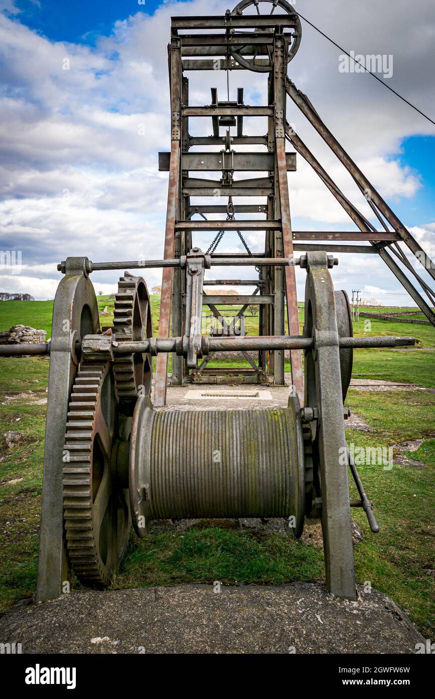 La roue à enroulement, la cage et le harnais en métal au-dessus de l'arbre principal de la mine Magpie, Sheldon, une mine de plomb conservée dans la région de Peak District National Pa Banque D'Images