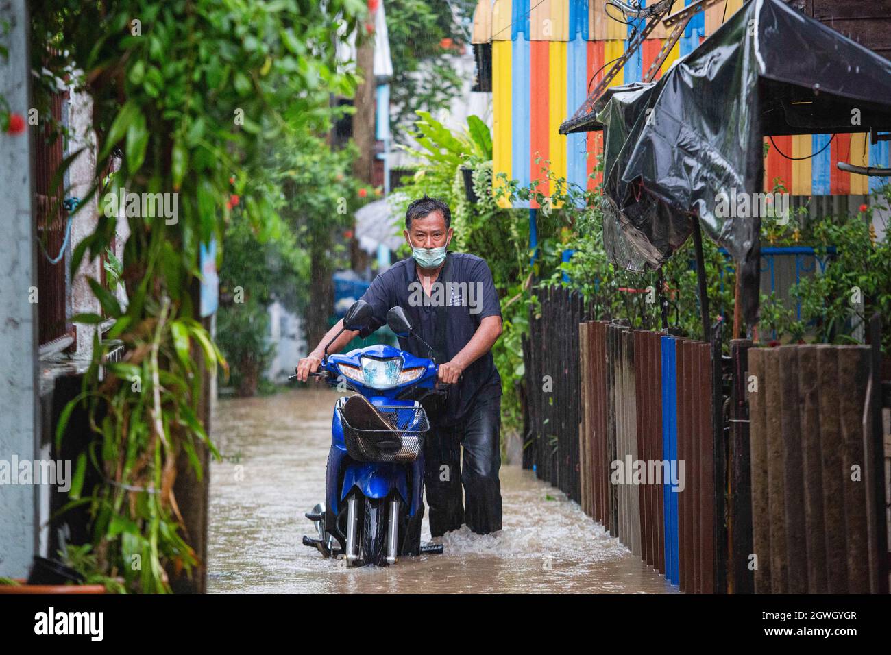 Nonthaburi, Thaïlande. 03ème octobre 2021. Le résident de Kor Kret traverse une allée submergée avec sa moto. Après la tempête de Dianmu, 20 provinces ont été touchées, l'eau s'est décomposée dans la province la plus proche de Bangkok. La communauté riveraine de Nonthaburi fait face à une inondation éclair qui change tous les jours. Kor Kret (île de la rivière à Nonthaburi) a le niveau de l'eau augmente chaque soir et baisse le matin selon la marée. (Photo de Varuth Pongsaponwatt/SOPA image/Sipa USA) crédit: SIPA USA/Alay Live News Banque D'Images