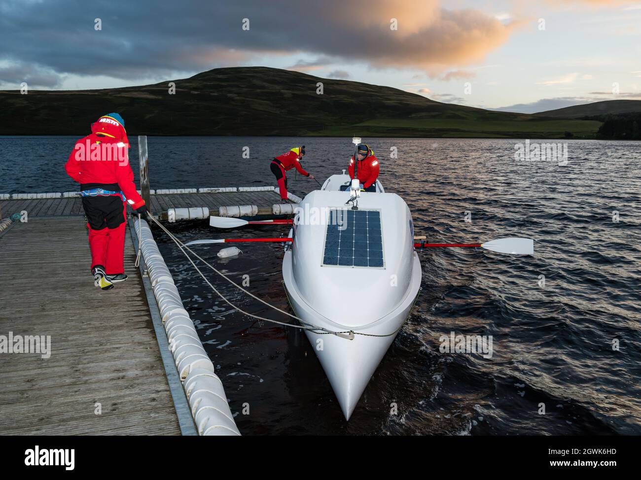 Des hommes lancent un bateau à rames sur le réservoir Whiteadder pour une séance d'entraînement pour le défi de l'Atlantique, East Lothian, Écosse, Royaume-Uni Banque D'Images