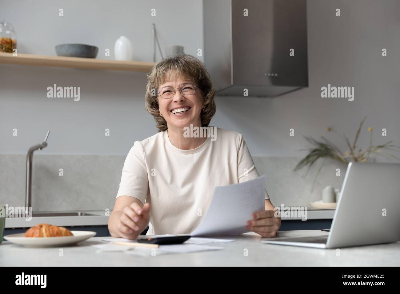 Portrait d'une vieille femme heureuse gérant le budget. Banque D'Images