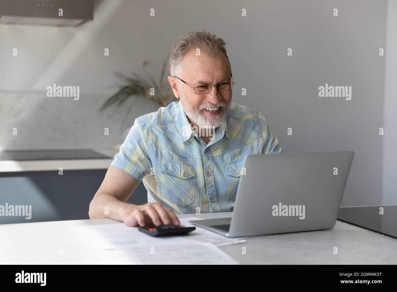 Bon vieux homme mature qui calcule le budget du ménage. Banque D'Images
