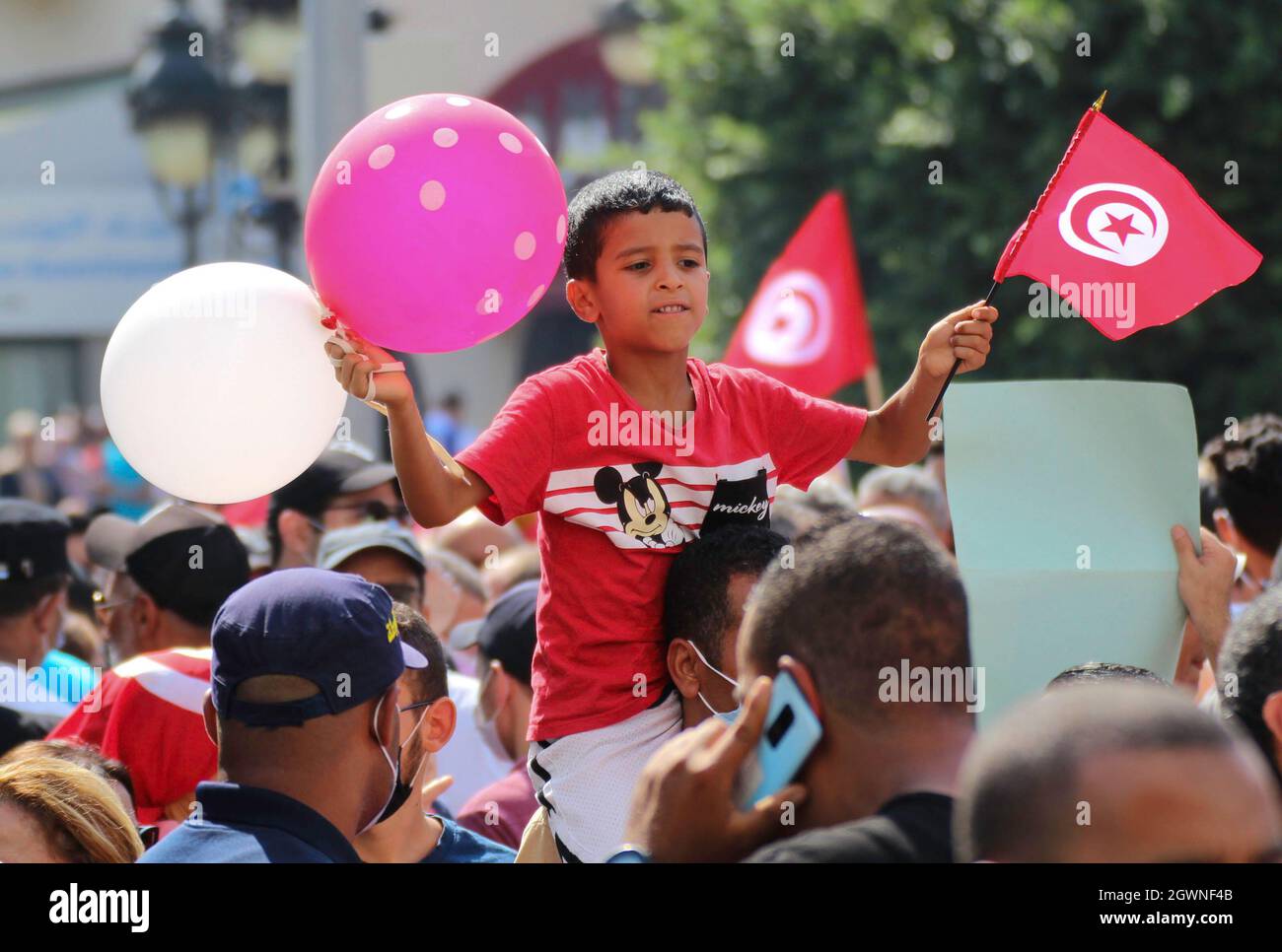 Tunis, Tunisie. 03ème octobre 2021. Un enfant tunisien est vu portant un drapeau et un ballon lors du rassemblement sur l'avenue Habib Bourguiba à Tunis. Des milliers de personnes se rallient au soutien du président Kais Saied après avoir suspendu la législature, limogé le gouvernement et pris le contrôle du pouvoir judiciaire, passant plus tard au pouvoir par décret. (Photo de Jdidi Wassim/SOPA Images/Sipa USA) crédit: SIPA USA/Alay Live News Banque D'Images