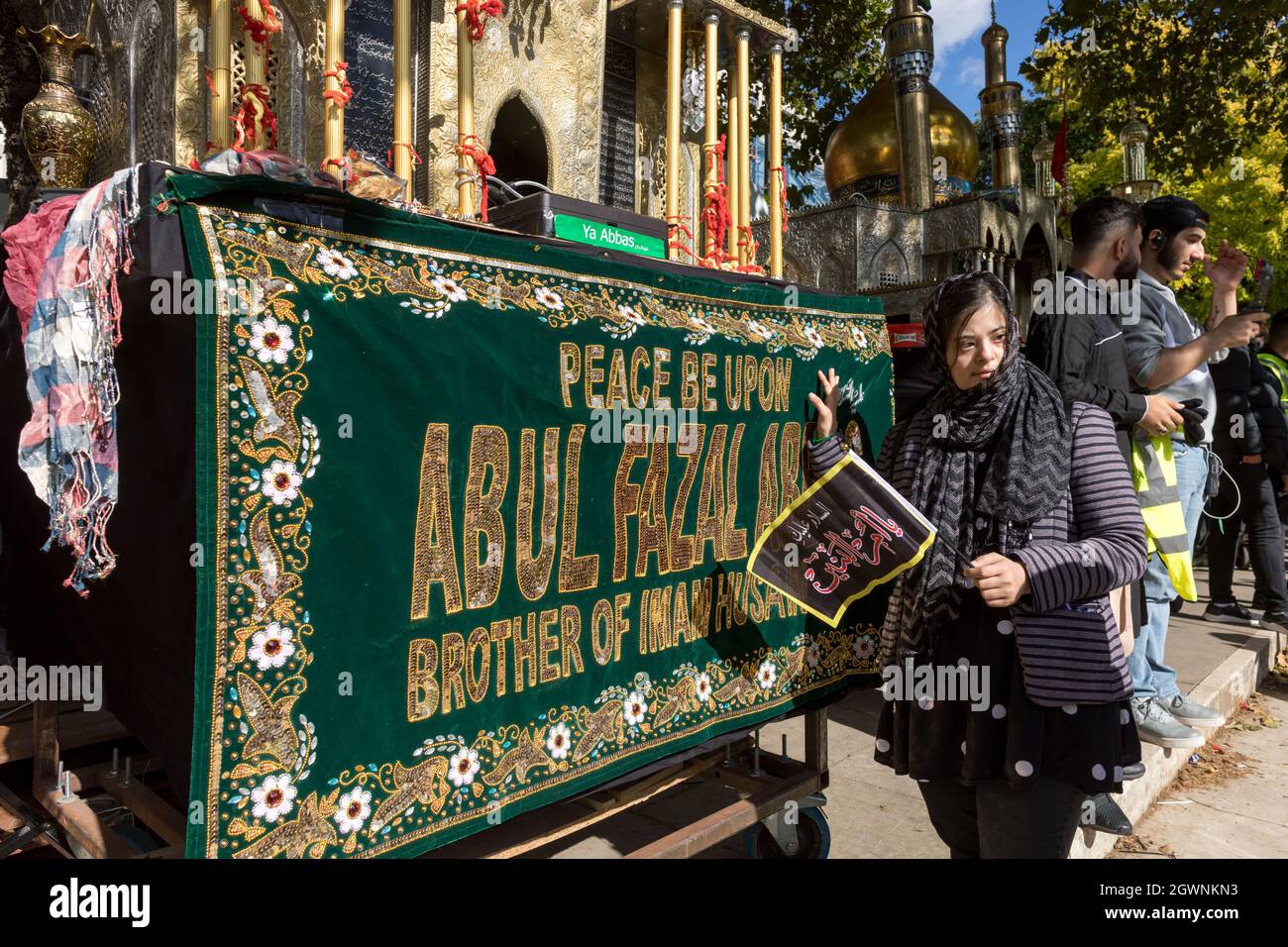 Un musulman vu touchant un sanctuaire répliqué, couvert d'une bannière qui dit «paix sur Abul Fazal Abbas frère de l'Imam Hussain».Imam Hussain, petit-fils du prophète Mahomet, a été martyrisé le 10 680 octobre après J.-C., pour avoir lutté contre la tyrannie de Yazid en Irak. Au fil des ans, des marches ont eu lieu pour commémorer Hussain pour son martyre dans le cadre du mouvement de solidarité Hussain. À Londres, accueilli par le Hussaini Islamic Trust UK, les musulmans se sont rassemblés et ont prié à Marble Arch, puis ont défilé jusqu'à Park Lane. Les participants ont également profité de l'occasion pour rétablir leur solidarité avec l'égalité des sexes Banque D'Images