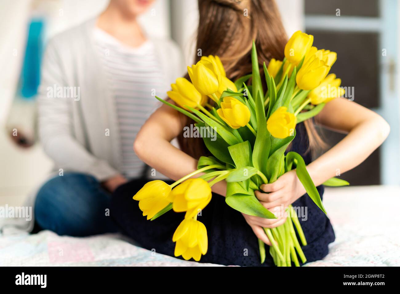 Joyeux Anniversaire Ou Fete Des Meres Jeune Fille Surprend Sa Maman Avec Le Bouquet De Tulipes Photo Stock Alamy