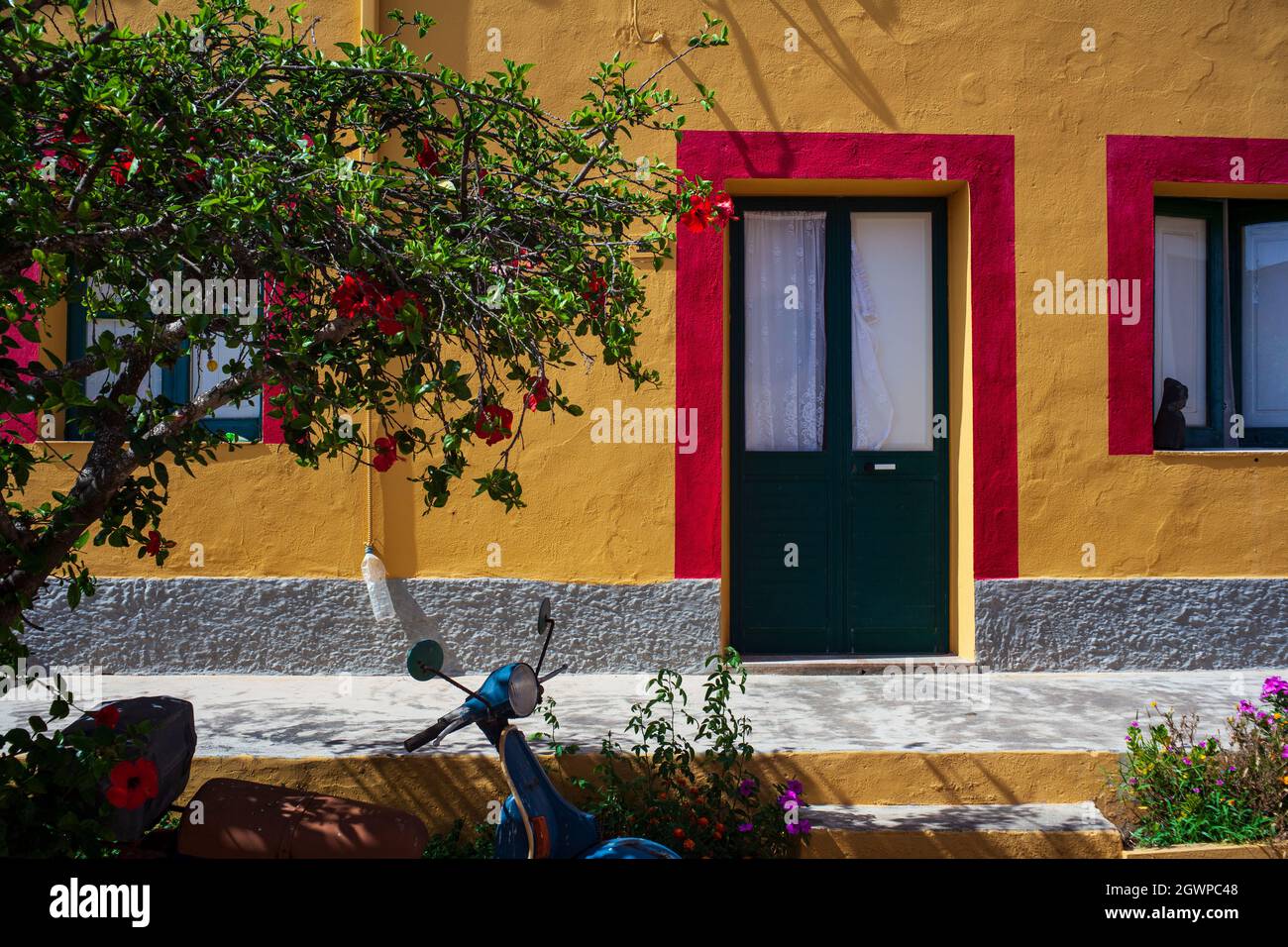 Vue sur une maison colorée typique de Linosa, de couleur rouge et orange avec porte verte Banque D'Images Vue sur une maison colorée typique de Linosa, de couleur rouge et orange avec porte verte Banque D'Images