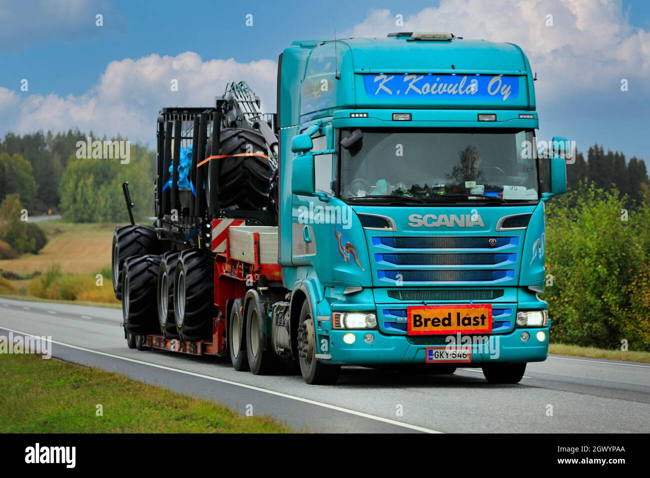 Une semi-remorque personnalisée Scania de K. Koigula transporte le porteur forestier de Logset en tant que large charge sur la route 52 en automne. Salo, Finlande. 24 septembre 2021. Banque D'Images