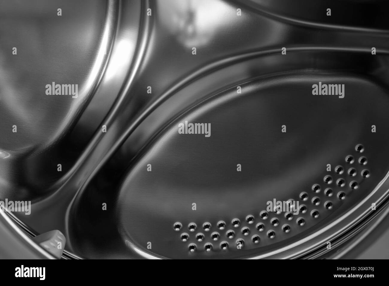 Tambour chromé d'un lave-linge avec couvercle ouvert. Banque D'Images