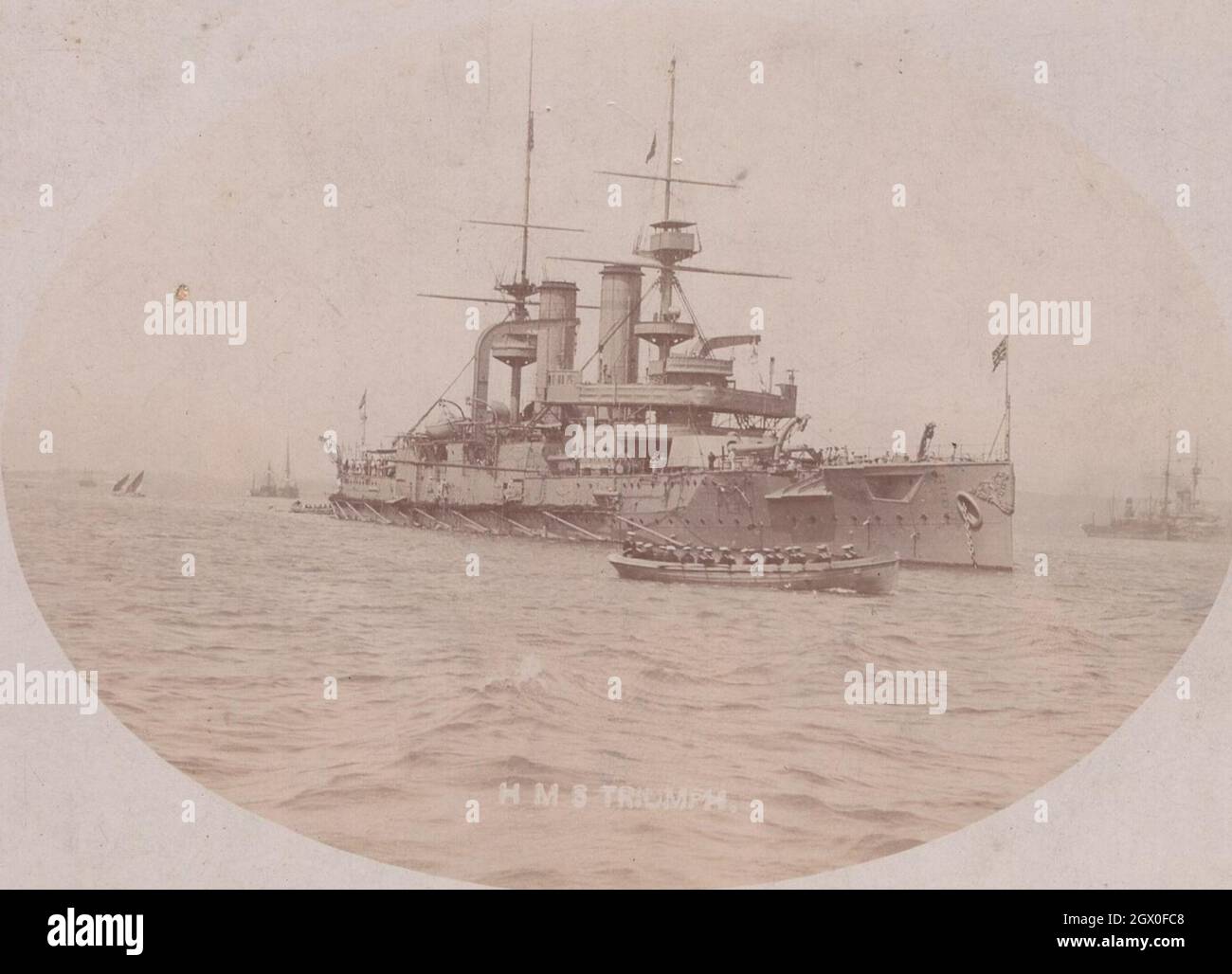 photo monochrome antique extra super rare du 1900s. Un des joyaux du navire de guerre de l'Empire britannique le HMS Triumph ( Libertad) . Ce navire était le deuxième des deux cuirassés de la Royal Navy de la classe Swiftsure. Les marines sont presque à leur portée destenations de commencer leur devoir. C'est une machine à la beauté parfaite. Emplacement: mer. Période: 1900s ( 1903, 1904 ?) Source : photocarte originale. Banque D'Images