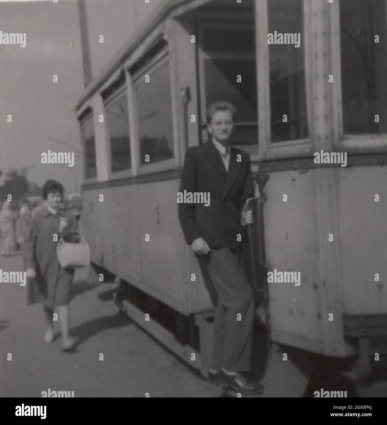 Photo d'époque. Jeune homme est debout au bord des escaliers du tram.Période de manœuvre dangereuse : années 1940 ou 1950.Source : photo originale. Banque D'Images