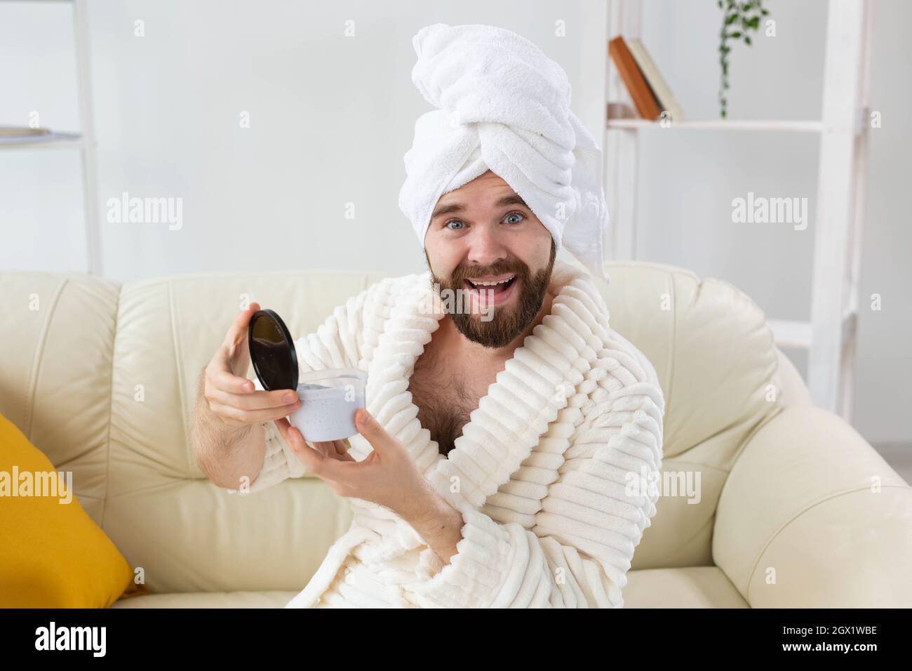 Portrait de l'homme appliquant une crème efficace sur sa peau faciale. Spa à la maison, soins du corps et de la peau pour homme concept. Banque D'Images