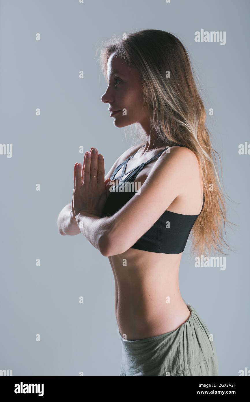 Une jeune fille de forme physique avec un corps sportif posé au studio sur fond gris. Modèle sportif souriant. Perte de poids. Un mode de vie sain. Sportif en bonne santé Banque D'Images