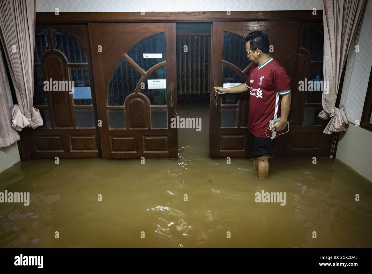 Nonthaburi, Thaïlande. 03ème octobre 2021. Un homme est vu dans sa maison inondée. La Thaïlande a été confrontée à des inondations éclair dues aux fortes pluies, au passage des marées et au drainage des eaux du barrage de Chao Phraya après que la tempête de Dianmu ait frappé le pays. De nombreux résidents sont confrontés à des inondations chaque année, mais cette année le niveau d'eau a immédiatement augmenté et a causé plus de dégâts que d'habitude. (Photo de Phobthum Yingpaiboonsuk/SOPA I/Sipa USA) crédit: SIPA USA/Alay Live News Banque D'Images