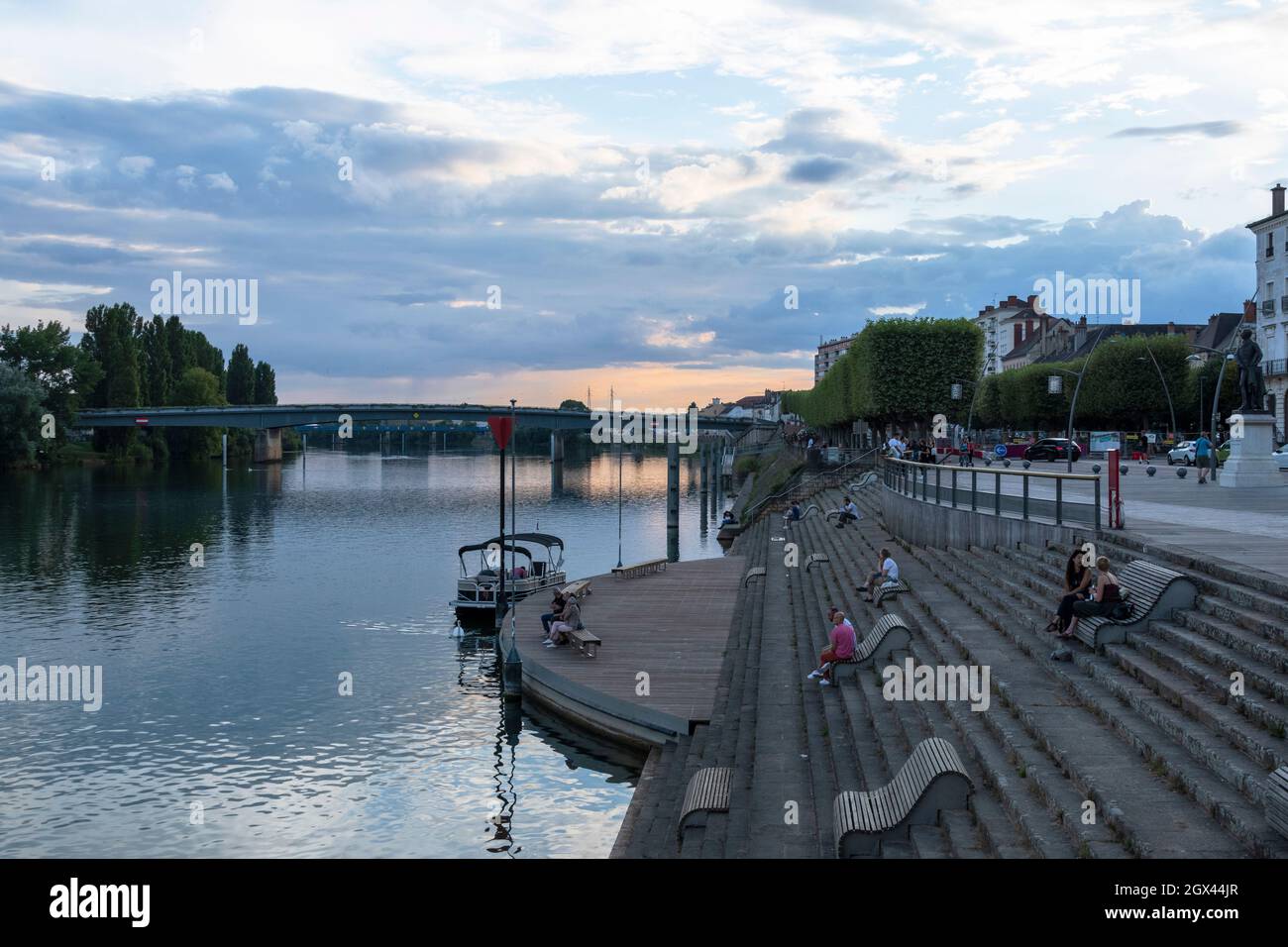 Les gens s'assoient au coucher du soleil à Chalon-sur-Saône, dans l'est de la France. Banque D'Images
