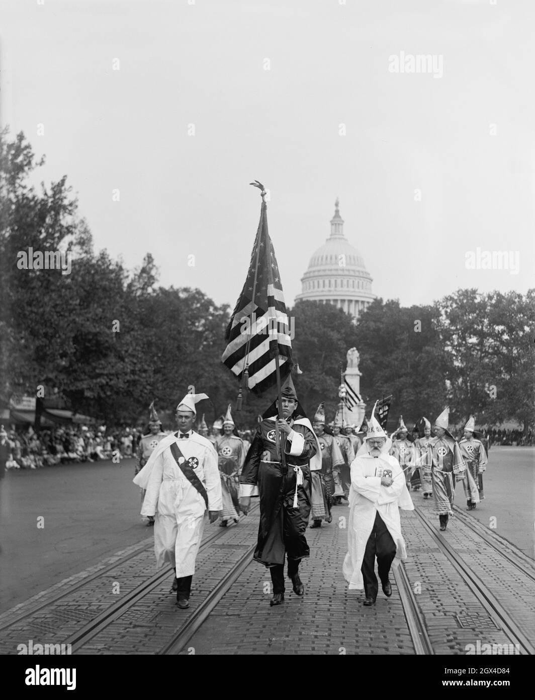 Photo d'époque datée du 13 septembre 1926 montrant des membres du Ku Klux Klan vêtus de robes en descendant de Pennsylvania Avenue à Washington, D.C., avec le drapeau des étoiles et des rayures et le dôme du Capitole en arrière-plan Banque D'Images