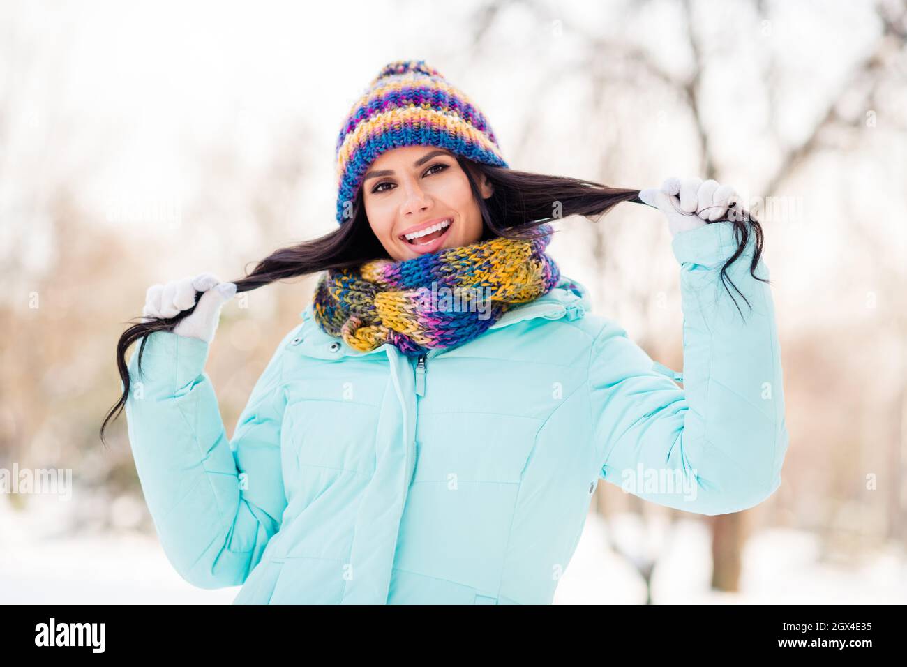 Photo de positive flirty dame tenir les queues porter tricoté casque écharpe  gants coupe-vent en hiver parc à l'extérieur Photo Stock - Alamy