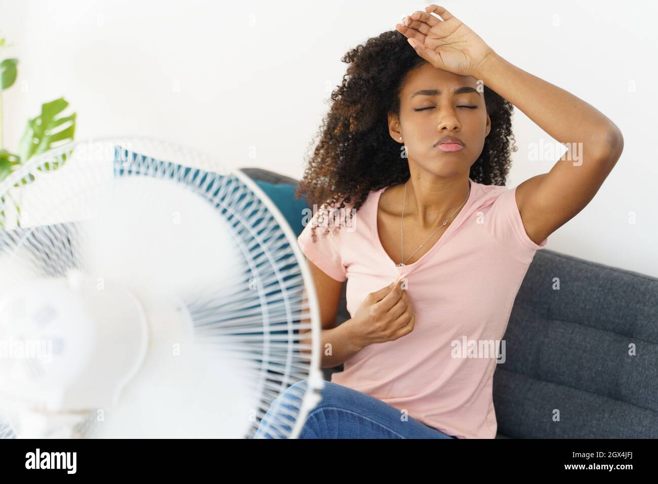 Femme africaine souffrant de la chaleur en face de ventilateur à accueil  Photo Stock - Alamy