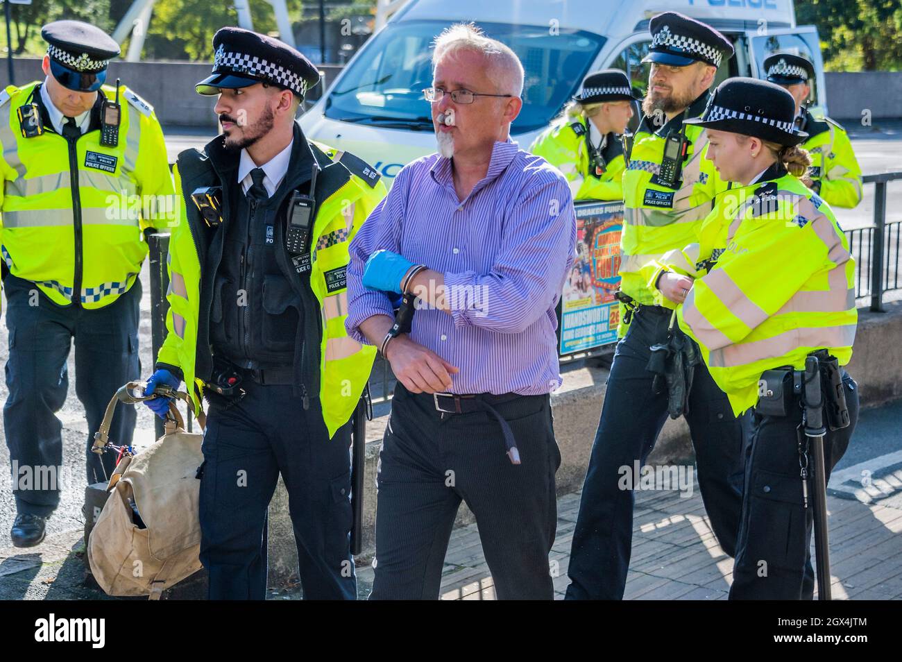 Londres, Royaume-Uni. 4 octobre 2021. Le dernier manifestant est hadmenotté puis emmené pour le transport vers un poste de police. La police procède à des arrestations après la rébellion d'isolation, une émanation de la rébellion d'extinction, qui bloque temporairement le pont Wandsworth. Leur protestation s'inscrit dans le cadre d'une campagne d'un mois pour tenter de forcer le gouvernement à fournir plus de soutien à l'isolation et à d'autres investissements d'économie d'énergie. Crédit : Guy Bell/Alay Live News Banque D'Images