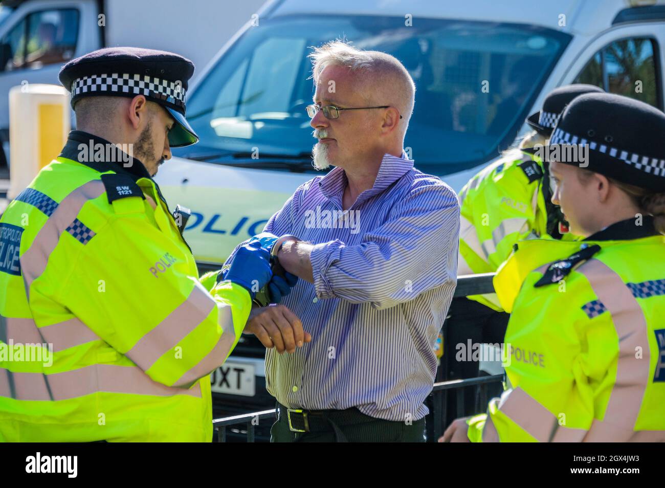 Londres, Royaume-Uni. 4 octobre 2021. Le dernier manifestant est hadmenotté puis emmené pour le transport vers un poste de police. La police procède à des arrestations après la rébellion d'isolation, une émanation de la rébellion d'extinction, qui bloque temporairement le pont Wandsworth. Leur protestation s'inscrit dans le cadre d'une campagne d'un mois pour tenter de forcer le gouvernement à fournir plus de soutien à l'isolation et à d'autres investissements d'économie d'énergie. Crédit : Guy Bell/Alay Live News Banque D'Images