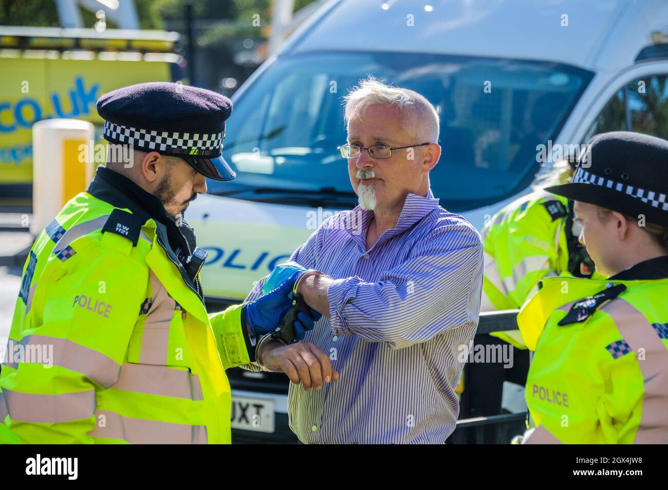 Londres, Royaume-Uni. 4 octobre 2021. Le dernier manifestant est hadmenotté puis emmené pour le transport vers un poste de police. La police procède à des arrestations après la rébellion d'isolation, une émanation de la rébellion d'extinction, qui bloque temporairement le pont Wandsworth. Leur protestation s'inscrit dans le cadre d'une campagne d'un mois pour tenter de forcer le gouvernement à fournir plus de soutien à l'isolation et à d'autres investissements d'économie d'énergie. Crédit : Guy Bell/Alay Live News Banque D'Images