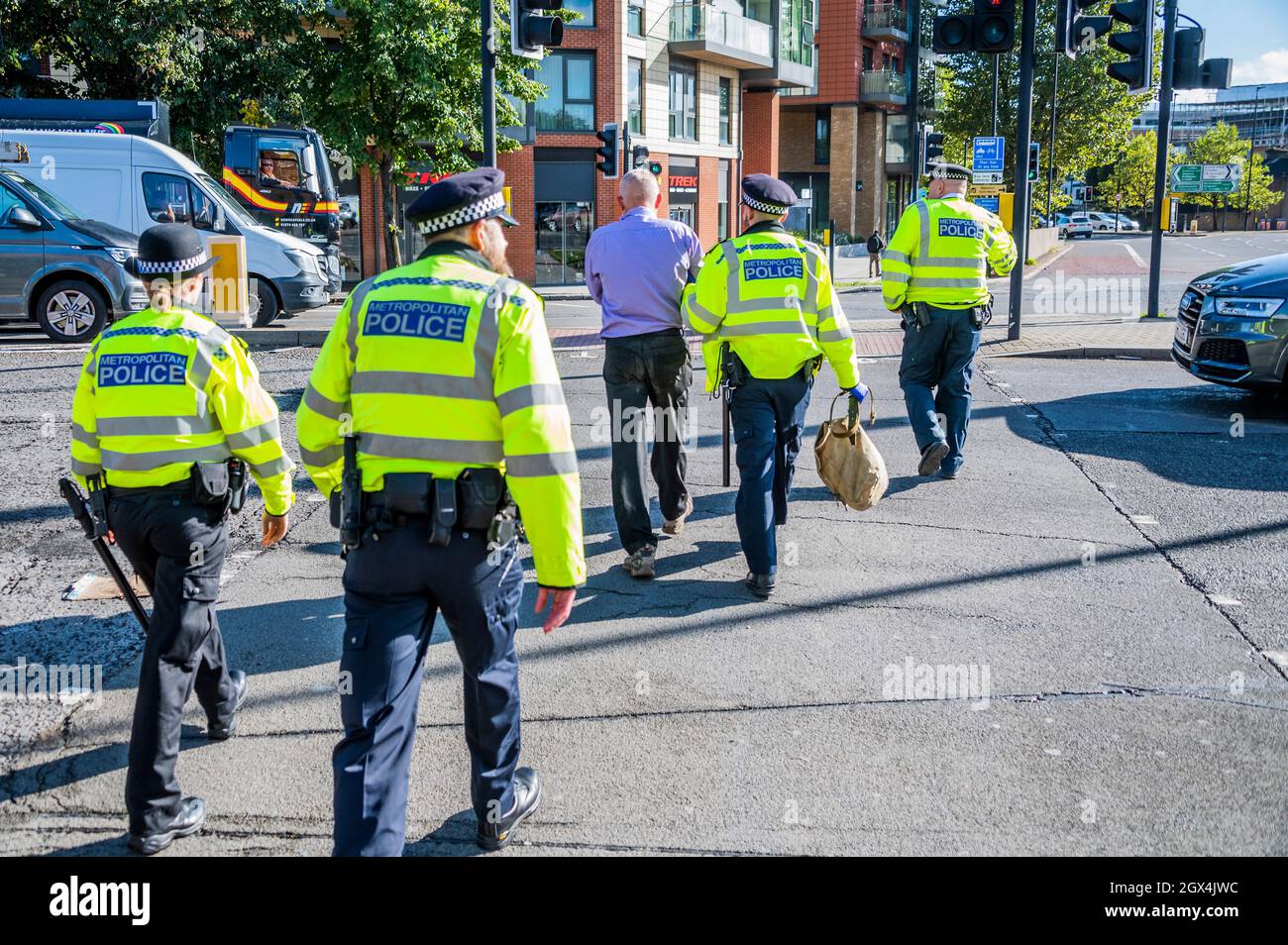 Londres, Royaume-Uni. 4 octobre 2021. Le dernier manifestant est hadmenotté puis emmené pour le transport vers un poste de police. La police procède à des arrestations après la rébellion d'isolation, une émanation de la rébellion d'extinction, qui bloque temporairement le pont Wandsworth. Leur protestation s'inscrit dans le cadre d'une campagne d'un mois pour tenter de forcer le gouvernement à fournir plus de soutien à l'isolation et à d'autres investissements d'économie d'énergie. Crédit : Guy Bell/Alay Live News Banque D'Images