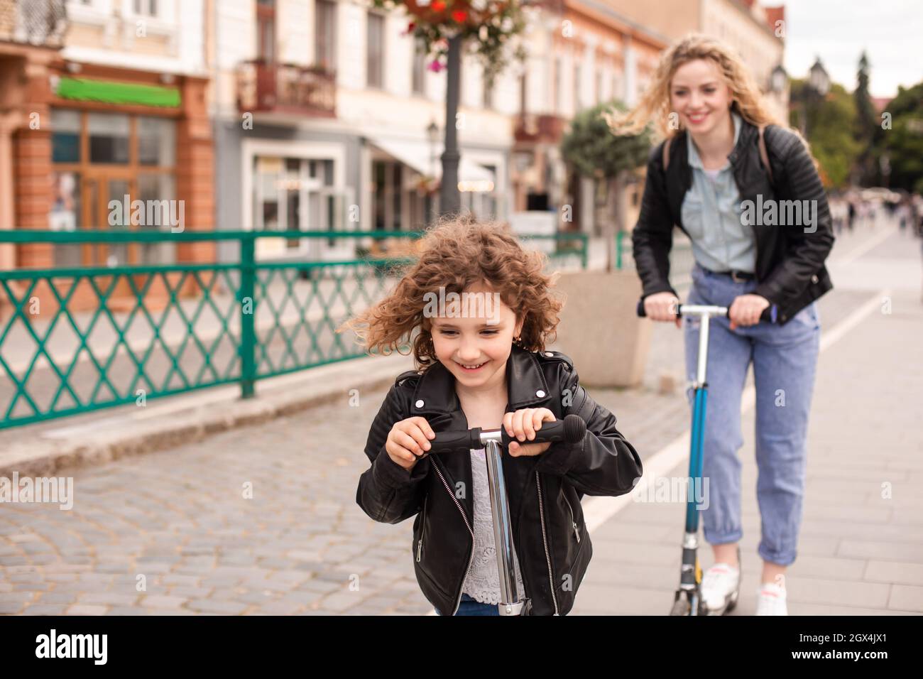 La jeune fille fait un scooter pour la première fois avec sa mère Photo Stock Alamy