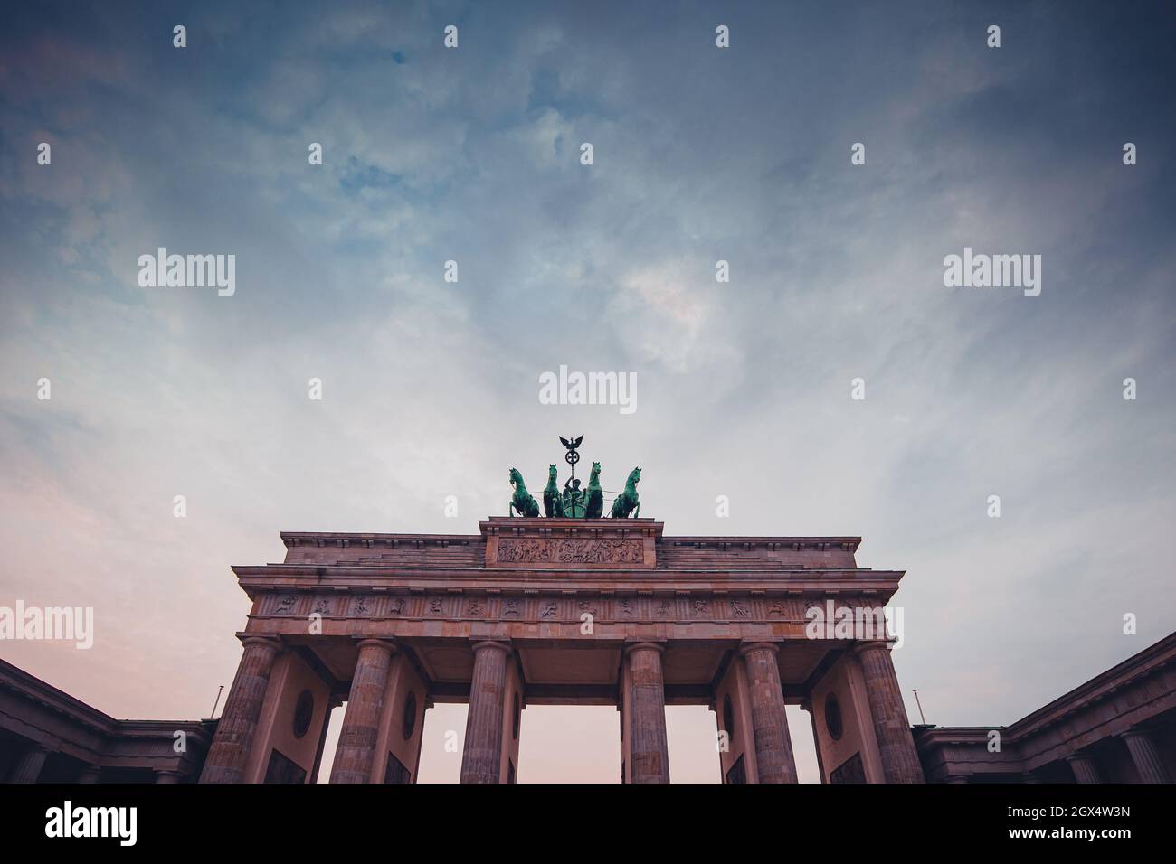 Partie supérieure de la porte de brandebourg à berlin lors d'une soirée colorée avec des nuages pittoresques. Monument colossal à berlin. Banque D'Images