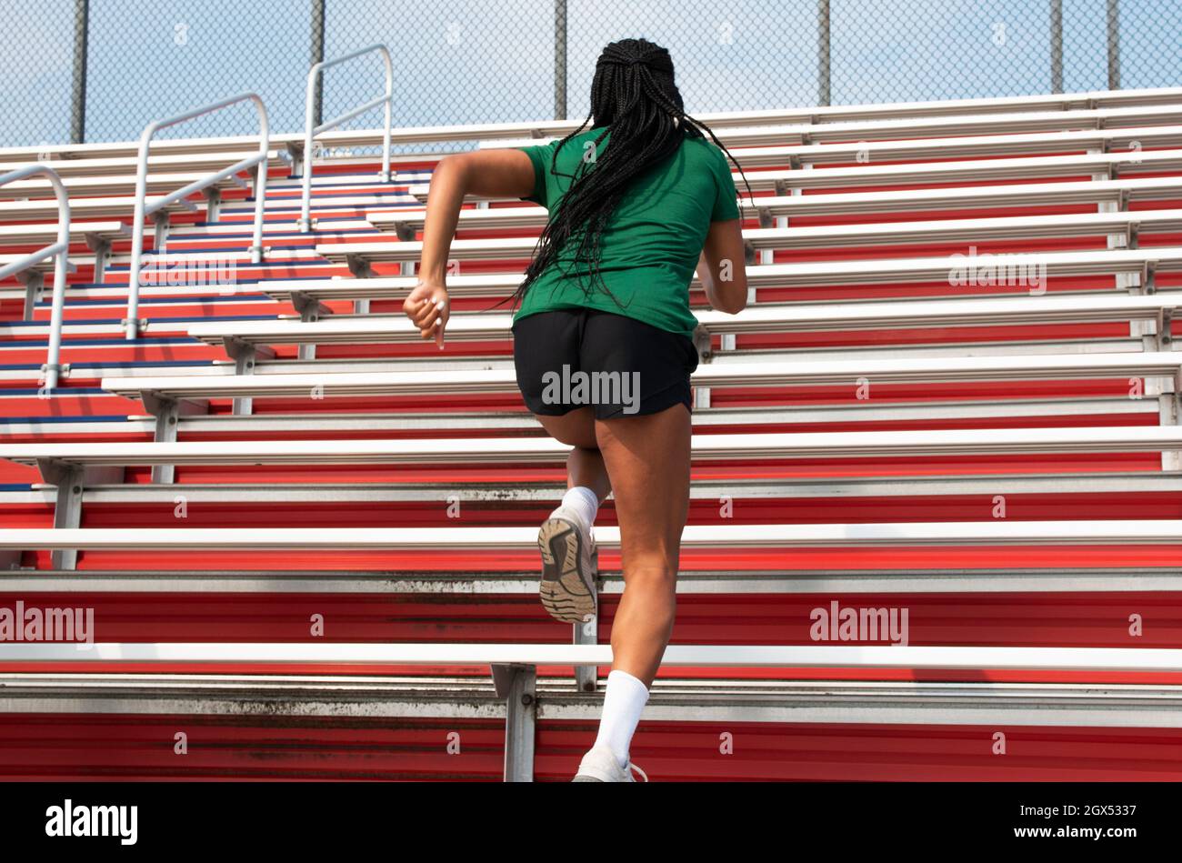 Vue arrière d'une athlète afro-américaine qui s'entraîne de près dans les gradins du stade. Banque D'Images
