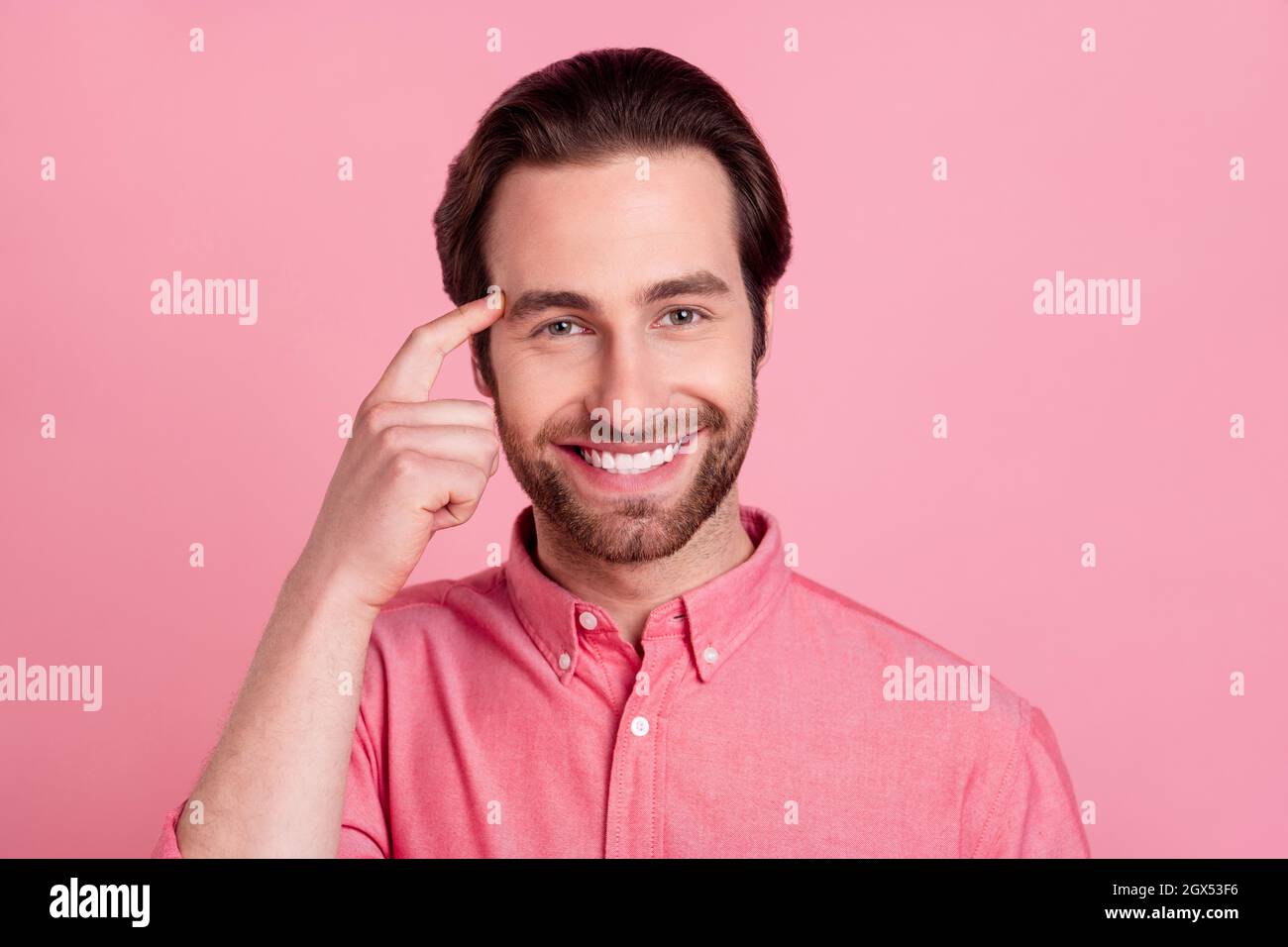 Portrait d'un sympathique gars gai brainny touchant le temple brainstorming isolé sur fond rose pastel couleur Banque D'Images