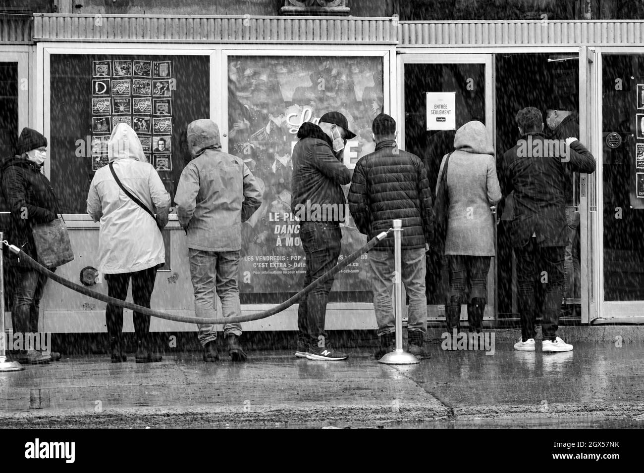 Montréal,Québec,Canada,le 26 mars 2021.les gens qui attendent en ligne sous la pluie pour aller voir un spectacle.Mario Beauregard/Alamy News Banque D'Images