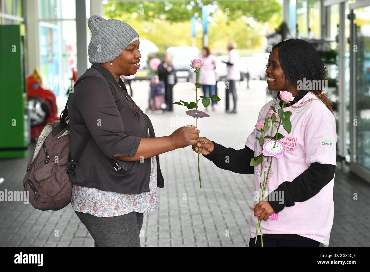 UTILISATION ÉDITORIALE SEULEMENT Un volontaire met une rose à Jane, de Manchester, lors d'un événement pop-up organisé par la société de santé féminine Hologic and PENVENTE Breast cancer, pour lancer la campagne « c'est le temps », soulignant l'importance de participer aux dépistages du cancer du sein lorsqu'ils sont éligibles, à Manchester. Date de la photo: Lundi 4 octobre 2021. Banque D'Images