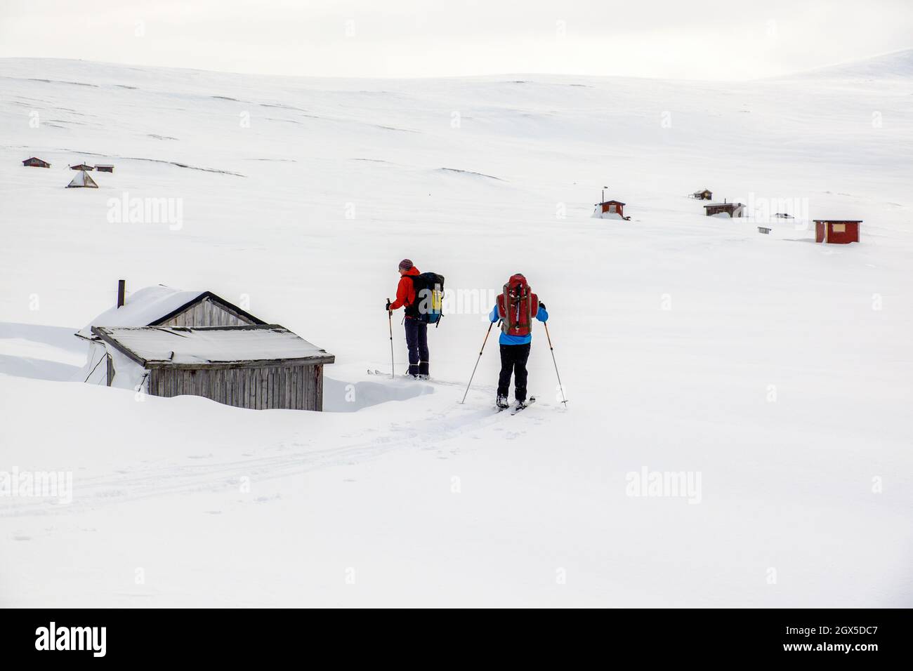 Deux skieurs de l'arrière-pays traversant un village sami dans le nord de la Suède Banque D'Images