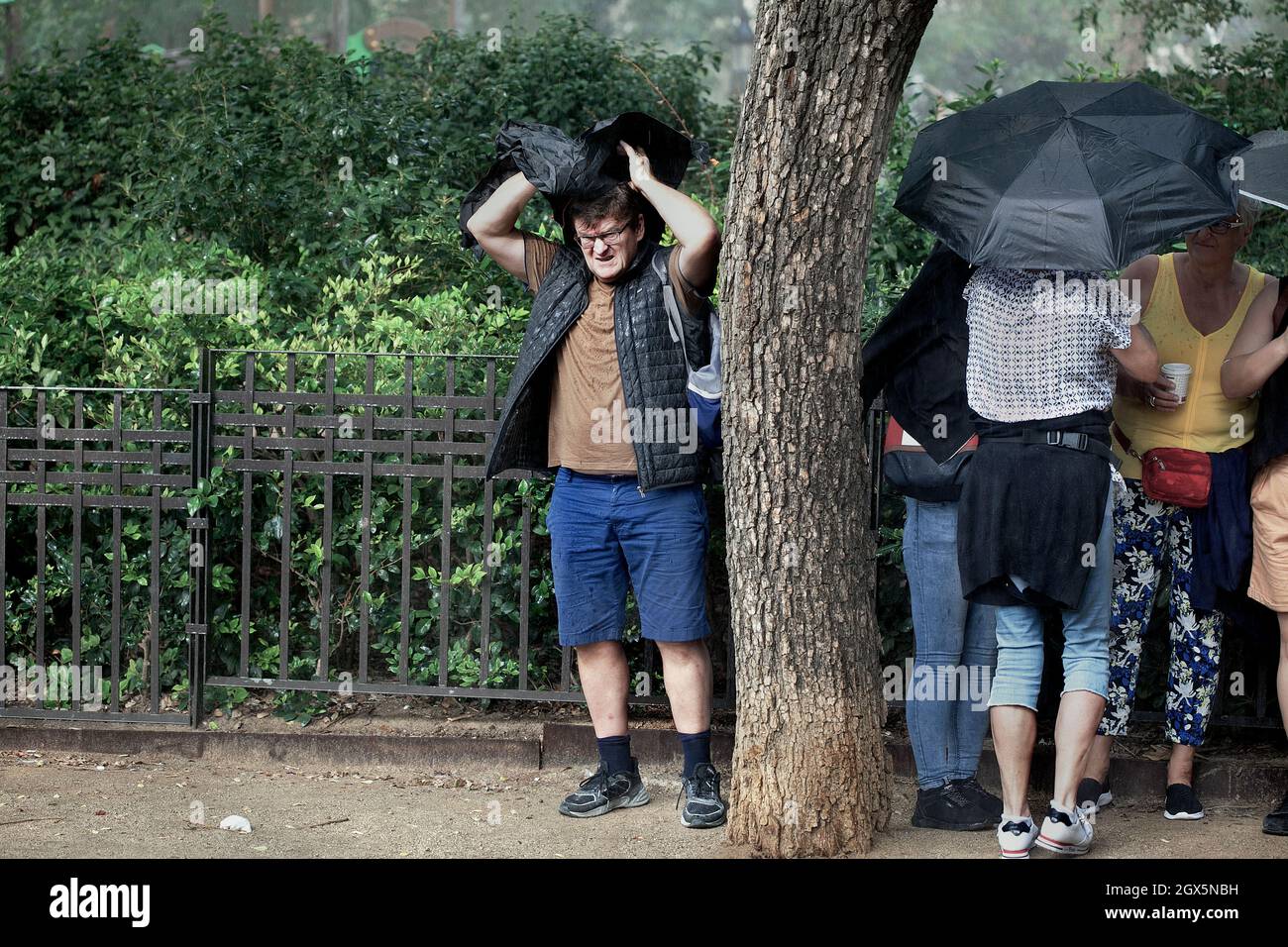 Tourisme luttant pour se protéger de la pluie, Barcelone, Espagne. Banque D'Images