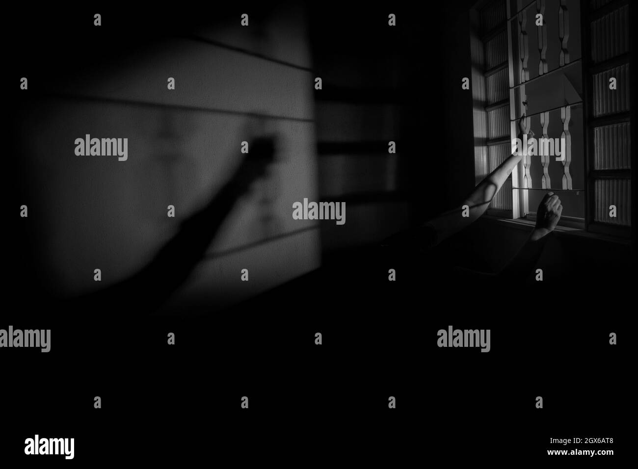 Bras d'une personne tenant la fenêtre. Image mystère en noir et blanc. Banque D'Images