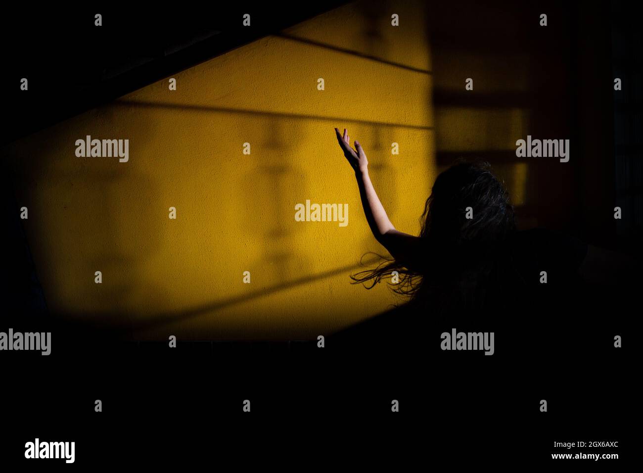 Silhouette d'une femme, dans le désespoir, avec un bras dans l'air et ses cheveux volent. Scène de nuit mystère. Banque D'Images