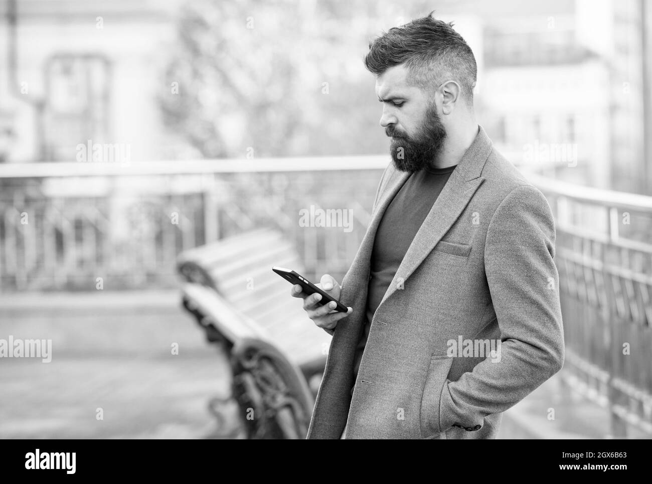 Rejoignez les utilisateurs en déplacement grâce au marketing par sms. Homme barbu lit des sms en plein air urbain. Messagerie texte. Appareil mobile. Nouvelle technologie. La vie moderne. Entreprise Banque D'Images