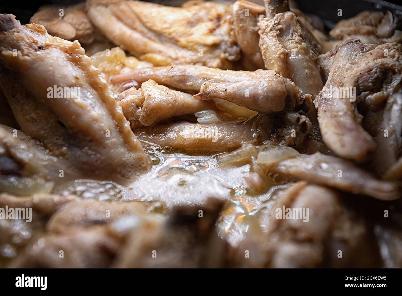 Les ailes de poulet sont cuites dans leur propre jus dans une casserole Banque D'Images