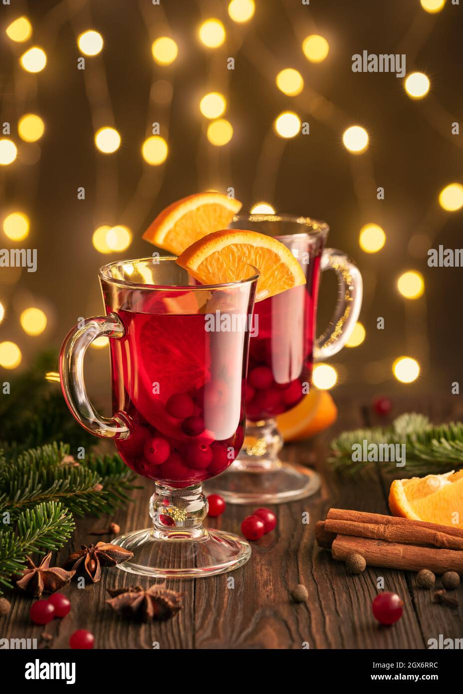 Vin chaud dans des verres sur fond de lumières de fées près de l'arbre de Noël Banque D'Images