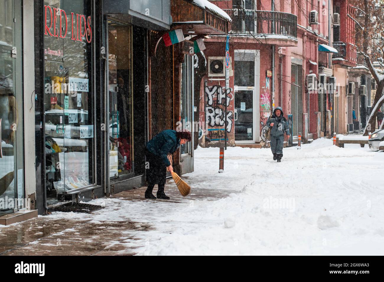 Une personne qui nettoie la neige d'une rue à Sofia, Bulgarie. Froid hiver en Europe. Rue blanche enneigée. Banque D'Images